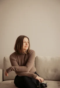woman smiling during a photoshoot posing on a coach