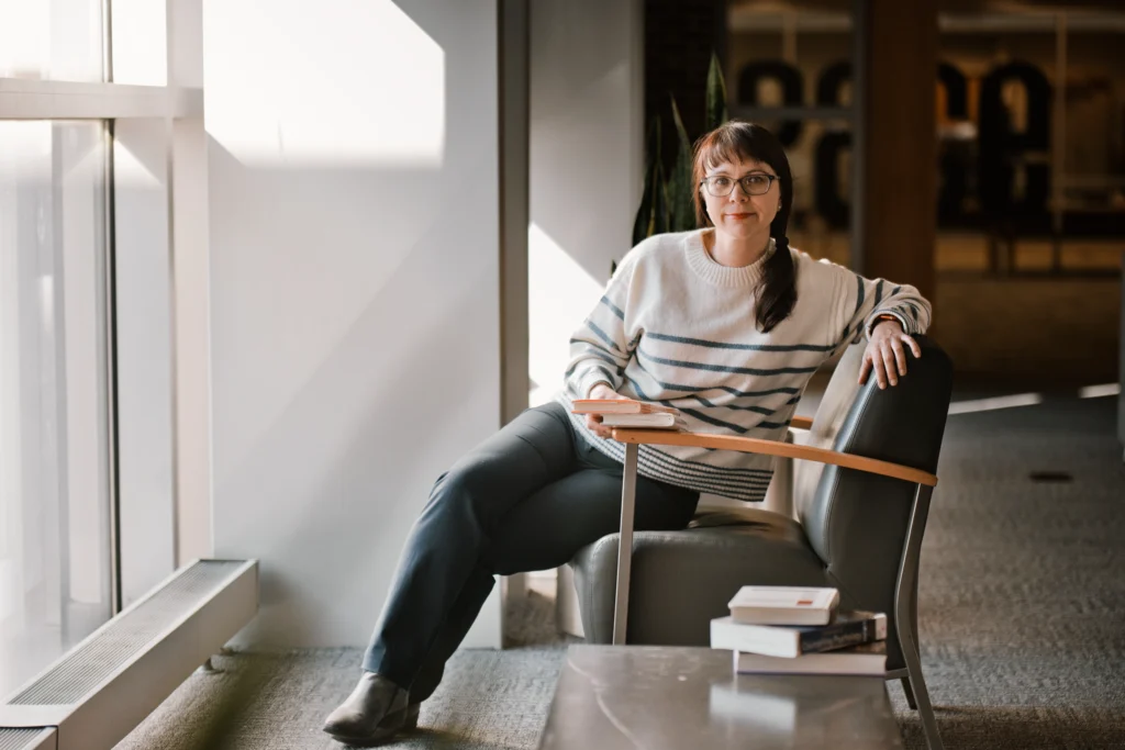a woman entrepreneur posing with a set of psychology books during a photography session