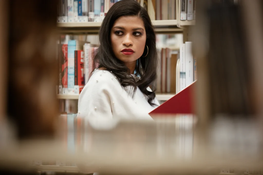 a Cincinnati college graduate posing with books