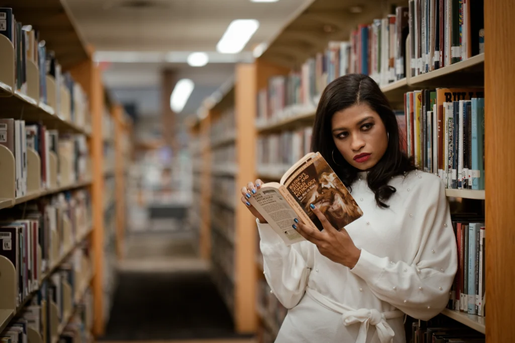 a Cincinnati college graduate posing with books
