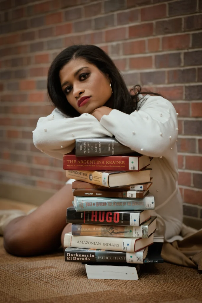 a Cincinnati college graduate posing with books