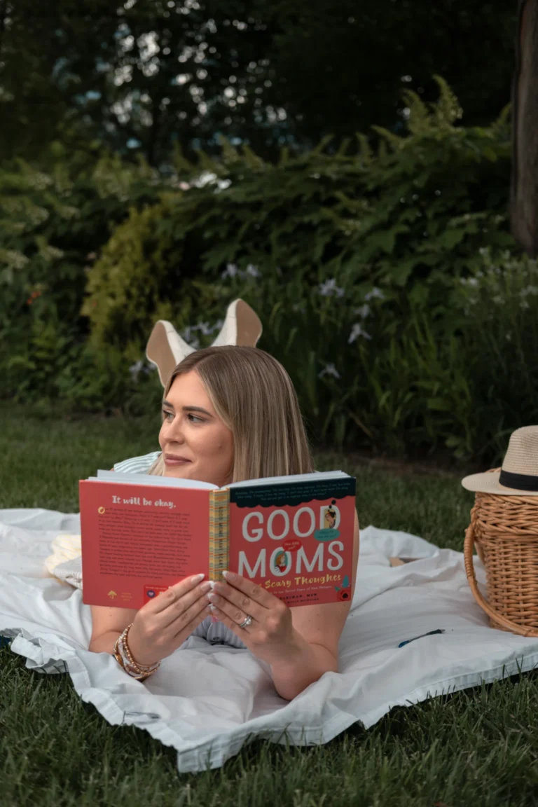 woman laying on a picnic blanket with a book in her hand branding photo session at sawyer point cincinnati ohio