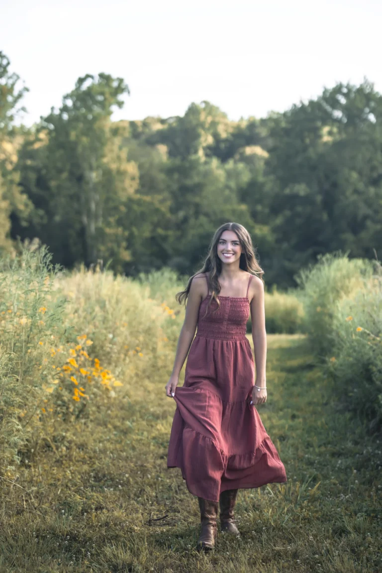 senior walking to the camera during photoshoot in flowers at Clover farm near Batavia Ohio and Cincinnati