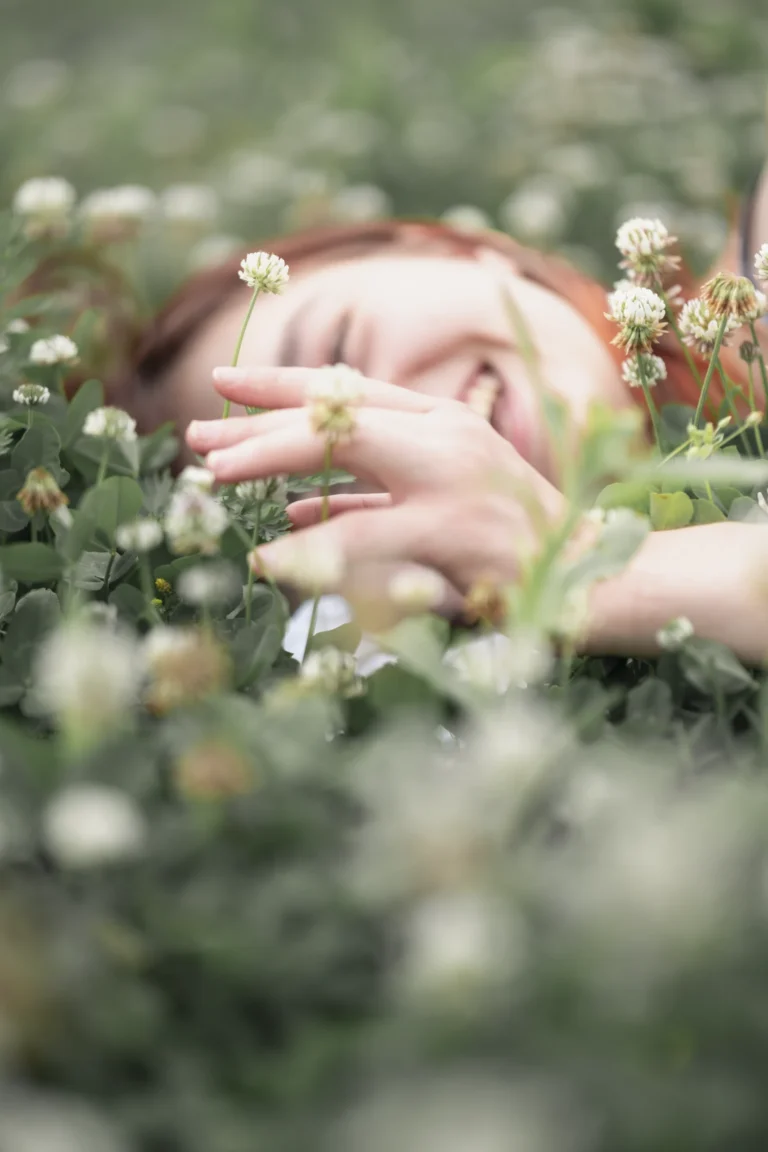 woman laying in a clover field senior photo session at park milford ohio